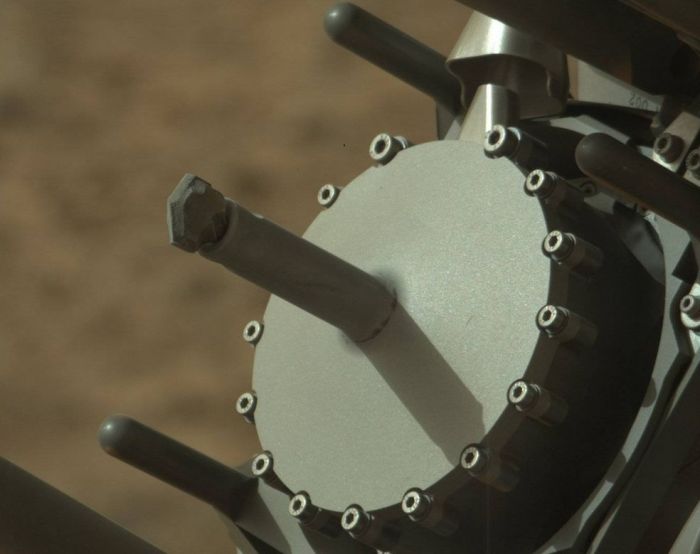A unique view of Curiosity's drilling following the sample gathering at "Big Sky". Captured by the rover's Mastcam, the image shows the drill head, couple with dusty drill bit. The tube surrounding it, coupled with the groves visible in the drill bit itself, is used to deliver tailings from the drilling into one of two sample ports in the circular drill head. Later, and by a process of vibration, these tailings are delivered to the CHIMRA "sorting" unit within the rover's robot "hand" which grades and sorts the sample material ready for onward transfer into Curiosity's analysis instruments
