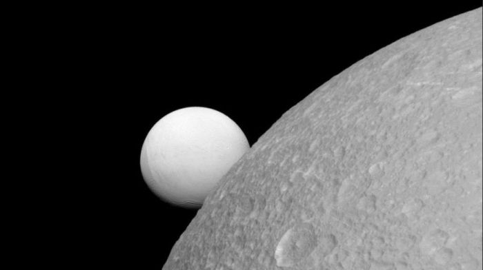 NOT an artist's impression. This is an actual image of Dione (foreground) with Enceladus "sitting" on its limb, captured by the Cassni spacecraft on September 8th, 2015. NASA/JPL-Caltech/SpS Institute 