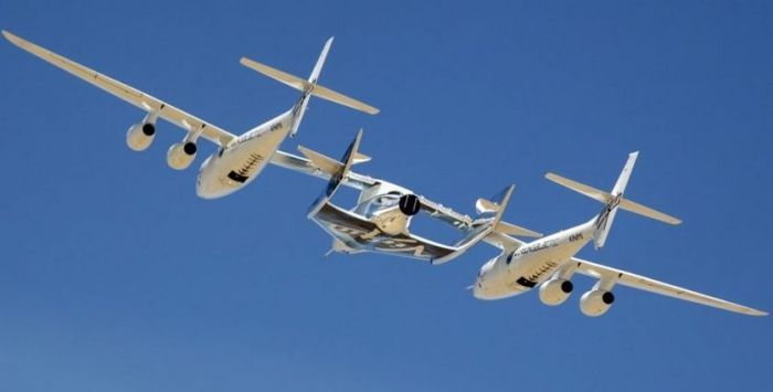 VSS Unity suspended between launch / carry aircraft WhiteKnightTwo during its only captive / carry flight in September 2016. Credit: Virgin Galactic