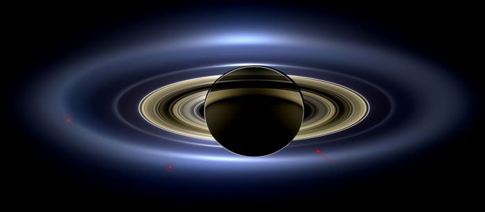 On July 19th, 2013, Cassini captured this remarkable shot of Saturn and its entire ring system as they eclipsed the Sun. captured at a distance of 1.2 million km (746,000 mi) from the planet. It spans a distance of 651,591 km (404,880 mi) across and uses 141 wide-angle shots collected over a 4-hour period, and shows the haze of Saturns's outer most "E" ring and, inward of it, the "G" ring, with Earth a tiny dot (arrowed) sitting between them. The more discrete ring system from the "F" ring through to the innermost "D" ring are visible, together with seven of Saturn's moons, of which two are ringed: Enceladus, on the left (see below) and Tethys, lower left). The colours seen are true, and have not been artificially enhanced Credit: NASA/JPL / Space Science Institute