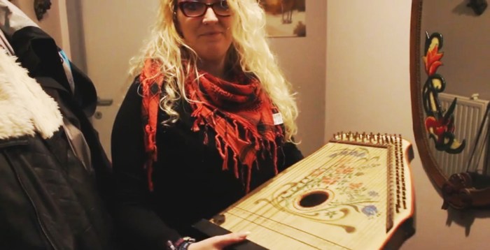 Jaimy Hancroft and two of her father's creation: a warnamandal, and on the wall behind her, a mirror painted by Mario 