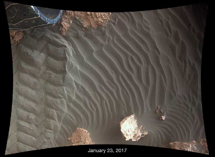 This pair of images shows effects of one Martian day of wind blowing sand underneath Curiosity on a non-driving day. Each image was taken just after sundown on on January 23rd, 2017 (Sol 1587) and January 24th, 2017 (Sol 1588). by the rover’s downward-looking Mars Descent Imager (MARDI). The area of ground shown in the images spans about 1 metre (39 inches) across. They reveal how the wind quickly scours the treadmarks left by one of the rover's wheels, even when protected by the vehicle. Credit: NASA/JPL / MSSS